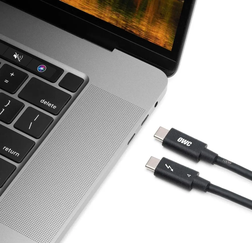 Two ends of an OWC Thunderbolt cable pointing towards a MacBook Pro